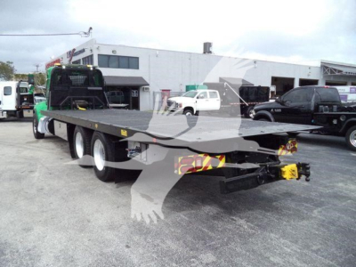 Peterbilt 348 rollback trailer with long flatbed and multiple axles, rear view showing hitch and warning triangles.