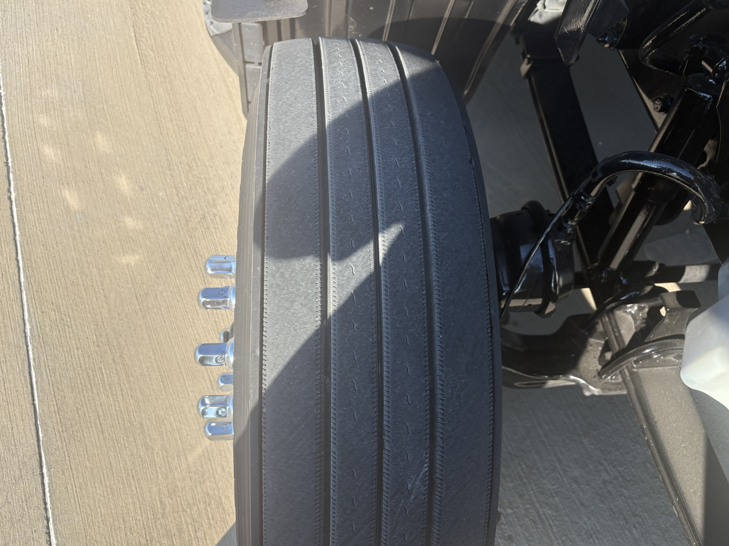 Wheel and suspension area of a 2022 Peterbilt 579 truck showing reinforced dual-tinch rear axle and wheel with five lug nuts.