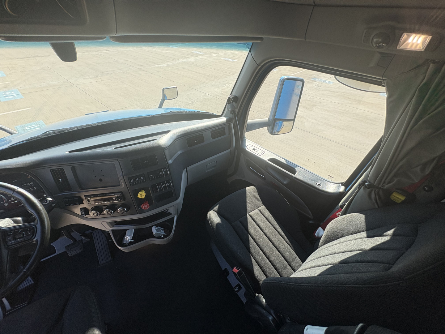 Peterbilt 579 truck cab interior showing dashboard controls and driver seat.