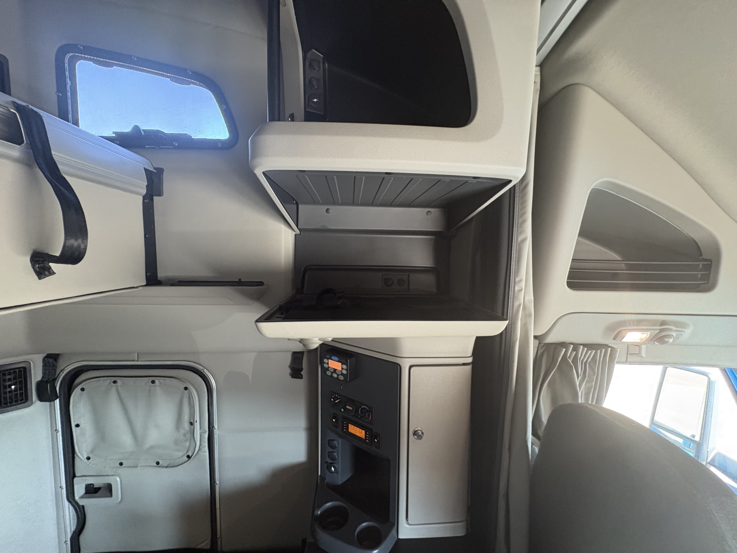 Interior cab area of a 2022 Peterbilt 579 showing a storage shelf and dashboard panel in the sleeper cab.