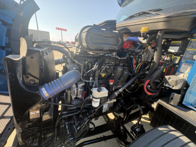 Peterbilt 579 engine bay view with exposed components, turbo intake, hoses, and wiring visible in the front section.