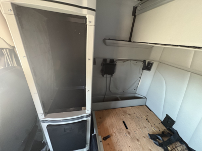 Peterbilt 579 sleeper truck interior cargo area with storage cabinet and plywood floor panel visible.