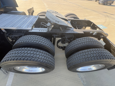 Peterbilt truck chassis with dual rear axles and dual-tire configuration, fifth-wheel kingpin area visible, fuel/air lines and frame members.