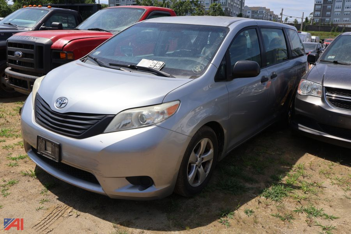 Silver 2016 Toyota Sienna minivan parked among other vehicles in a lot, front-left view.