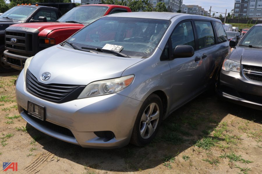 Silver 2016 Toyota Sienna minivan parked among other vehicles in a lot, front-left view.