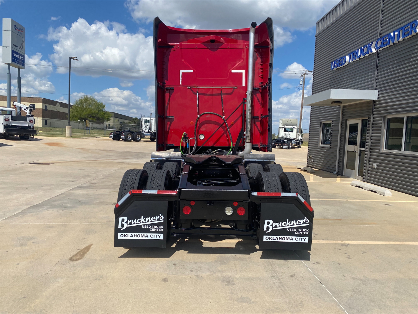 Truck rear view showing red sleeper cab and fifth wheel, with mud flaps labeled Bruckner's Oklahoma City.