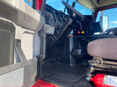 Truck cab interior of a 2020 Mack AN64T70 showing dash, steering wheel, driver seat, and floor area inside the sleeper model.