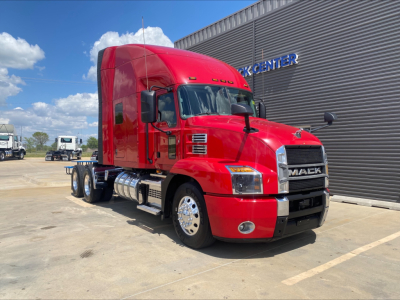 Mack AN64T70 tractor in red exterior showing cab and sleeper, front grille with MACK badge, chrome fuel tanks, and dual rear axles.