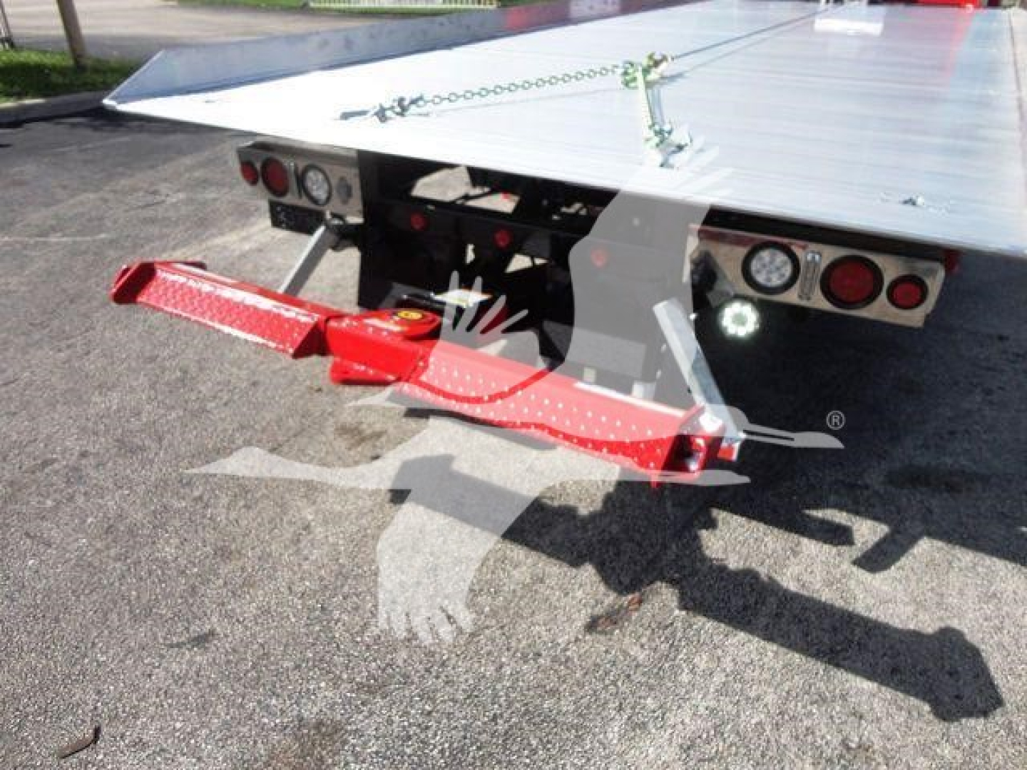 Peterbilt rollback truck bed rear with red towing arm and warning lights.