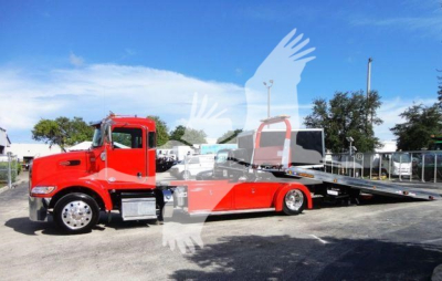 Red Peterbilt 337 rollback tow truck with flatbed, side view