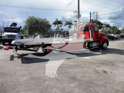 Peterbilt 337 rollback wrecker truck in red color with flatbed extendable carriage, side view showing chassis and wheels.