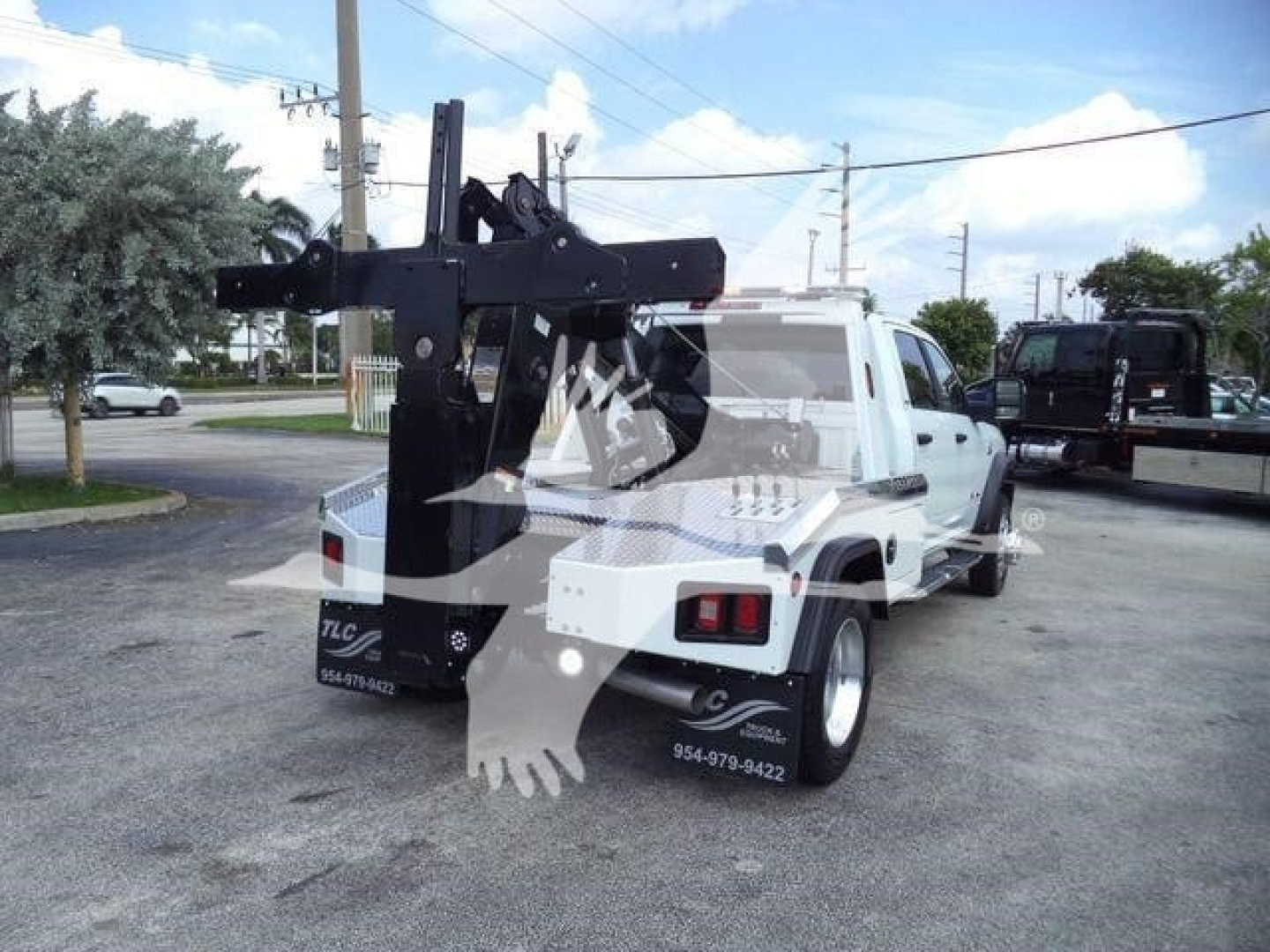 Truck bed with heavy-duty winch mount and rear hydraulic arm, Ram 5500 SLT, white utility truck, side view showing rear chassis and tow hitch.