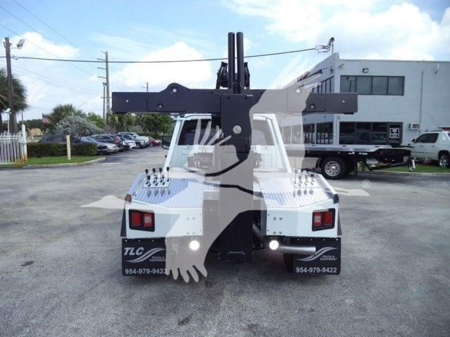 Ram 5500 winch truck rear view showing heavy-duty crane and winch mounting with model markings and contact numbers.