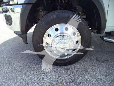 Front wheel and tire of a Ram 5500 truck showing chrome hubcap with Ram logo and tire tread.