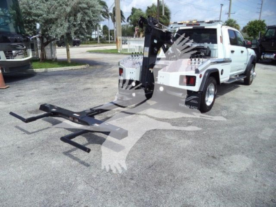 Trucked pickup with winch system attached showing large hook and towing frame in rear, white Ram 5500/SLT with crane winch assembly.