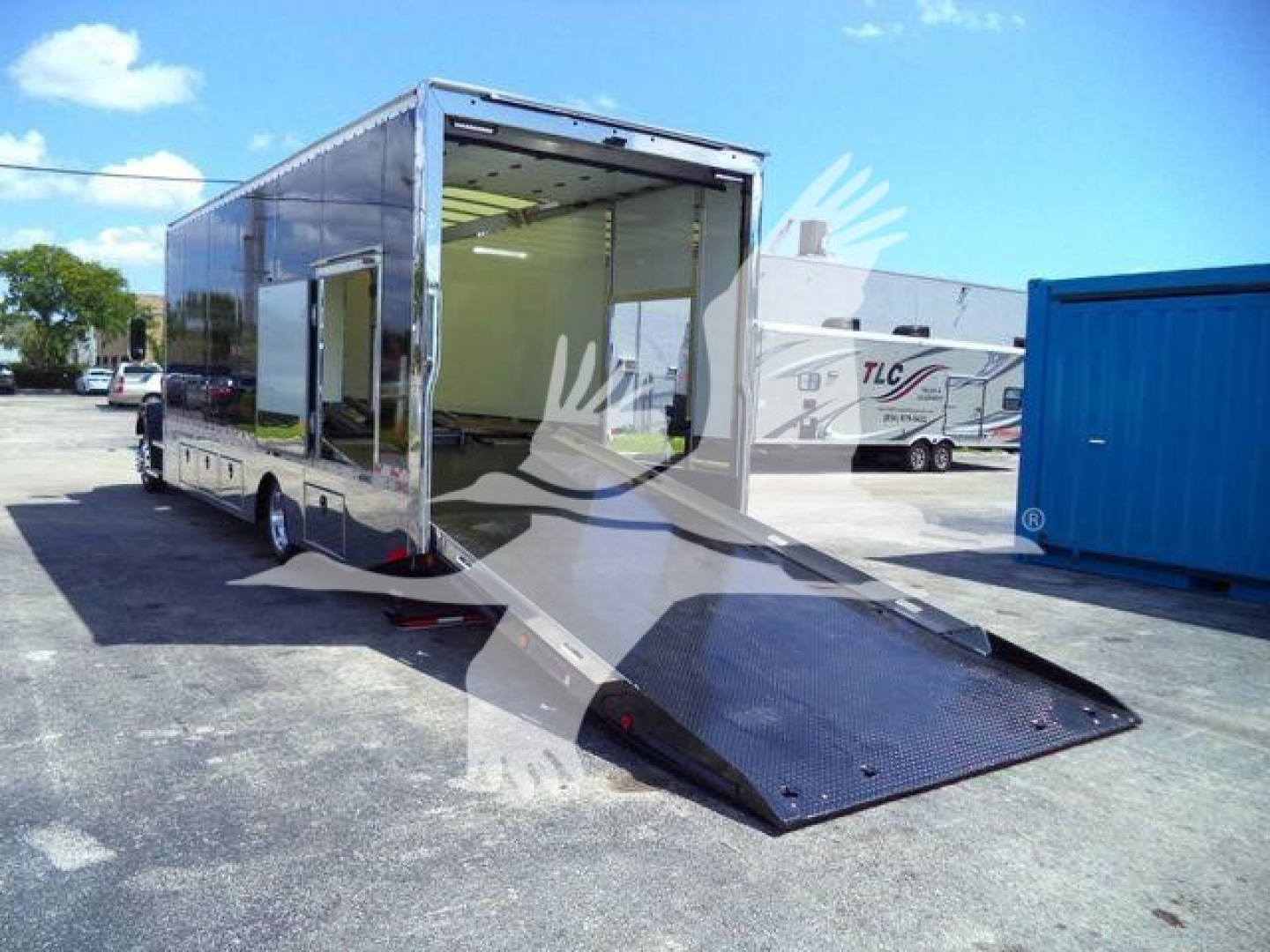 Truck trailer with ramp gate lowered showing interior space and side entry; aluminum enclosure, rear loading ramp, open rear door, Mack MD6 stock photo.