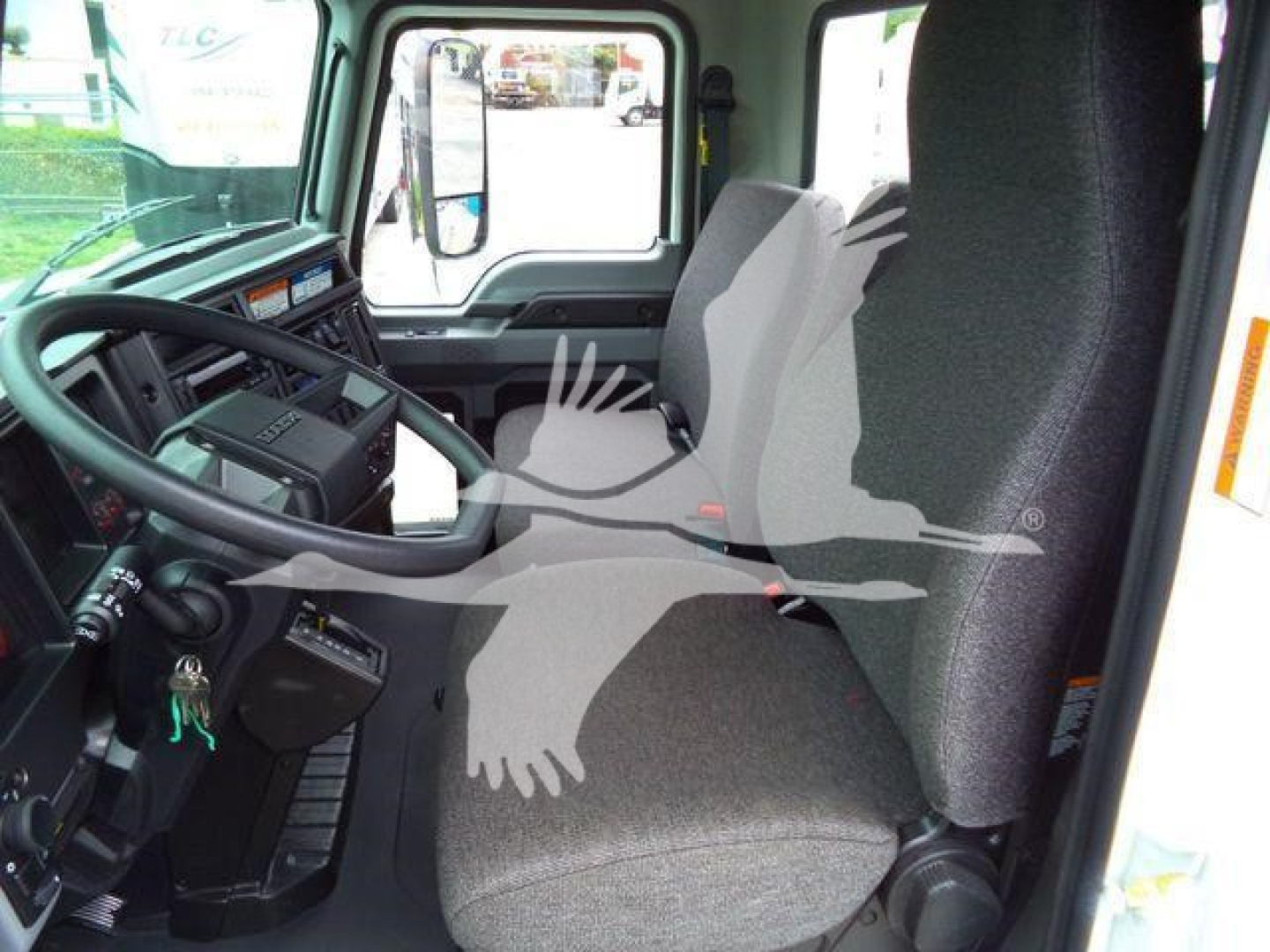 Cab interior of a 2026 Mack MD6 truck showing steering wheel, driver seat, and dashboard with keys in ignition.