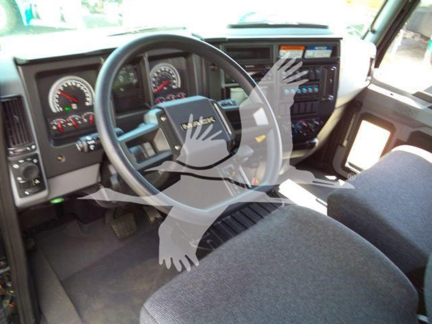 Mack MD6 truck cabin dashboard and steering wheel, inside view showing gauges and control panel.