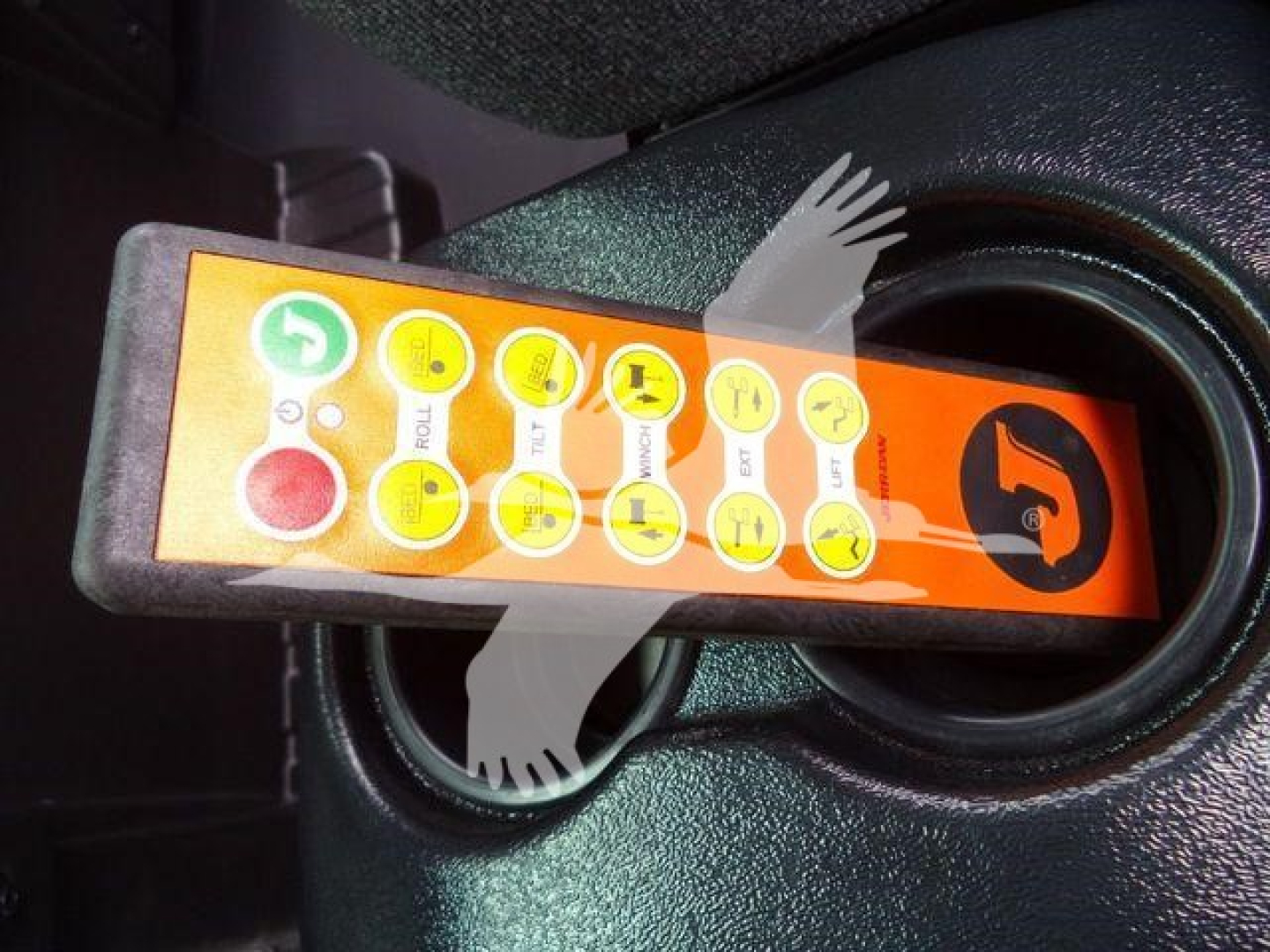 Control panel with yellow circular icons on orange background inside Mack MD6 cab area; visible in-control graphic showing various functions; circular shifter area and a symbol on the right.