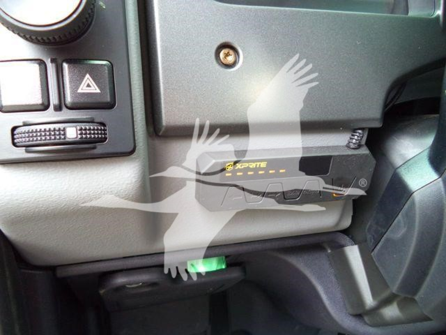 Mack MD6 dashboard area showing a black EzPite? device with yellow markings installed under the steering column. Green lever visible below.