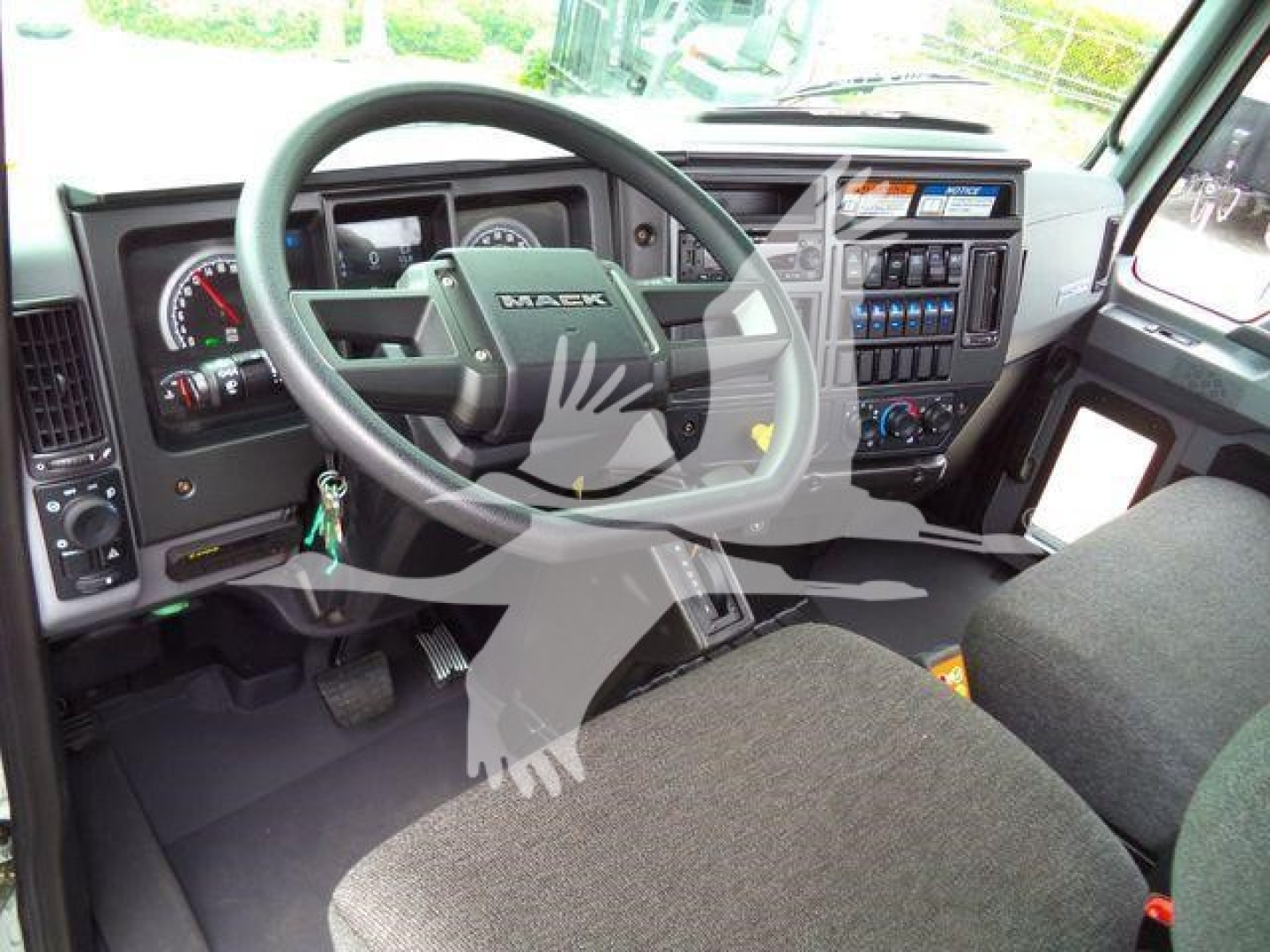 Dashboard and steering wheel view of a Mack MD6 truck cab with instrument cluster and control panel visible.