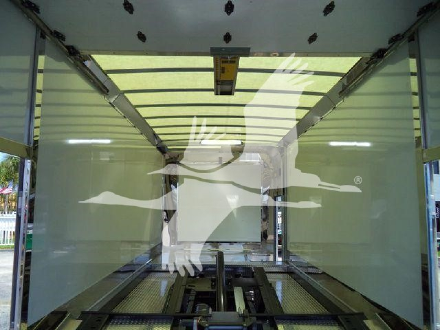 Mack MD6 rollback truck cabin interior showing cargo area with side walls and floor rails, overhead ceiling and loading access.