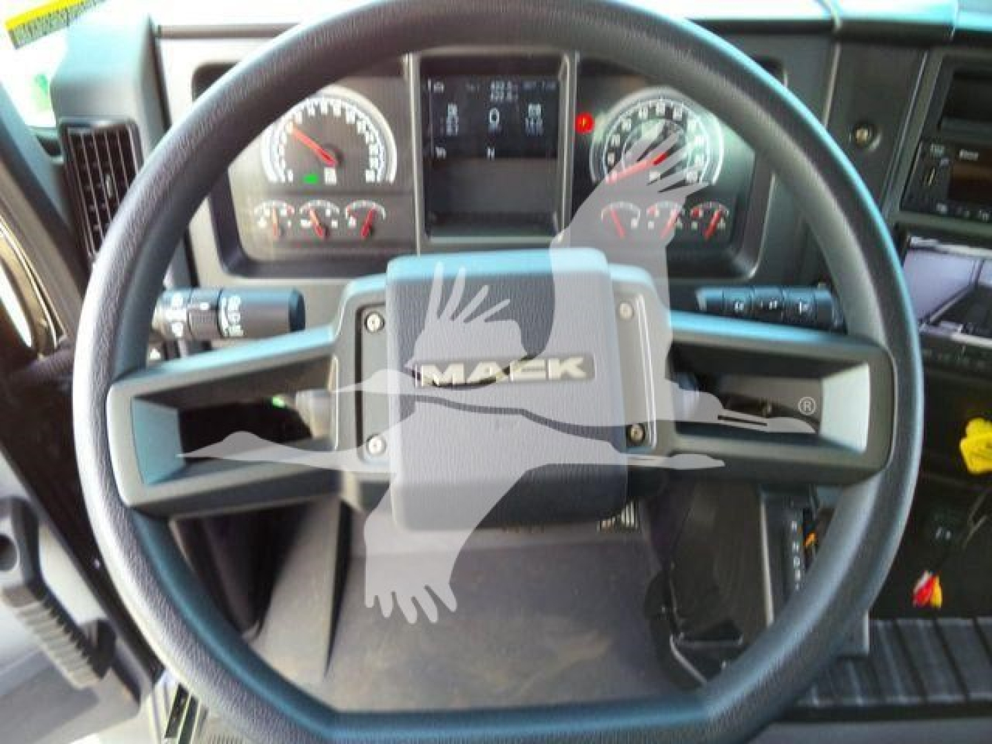 Steering wheel and dashboard of a 2026 Mack MD6 truck showing the Mack emblem on the steering wheel and instrument cluster in the background.