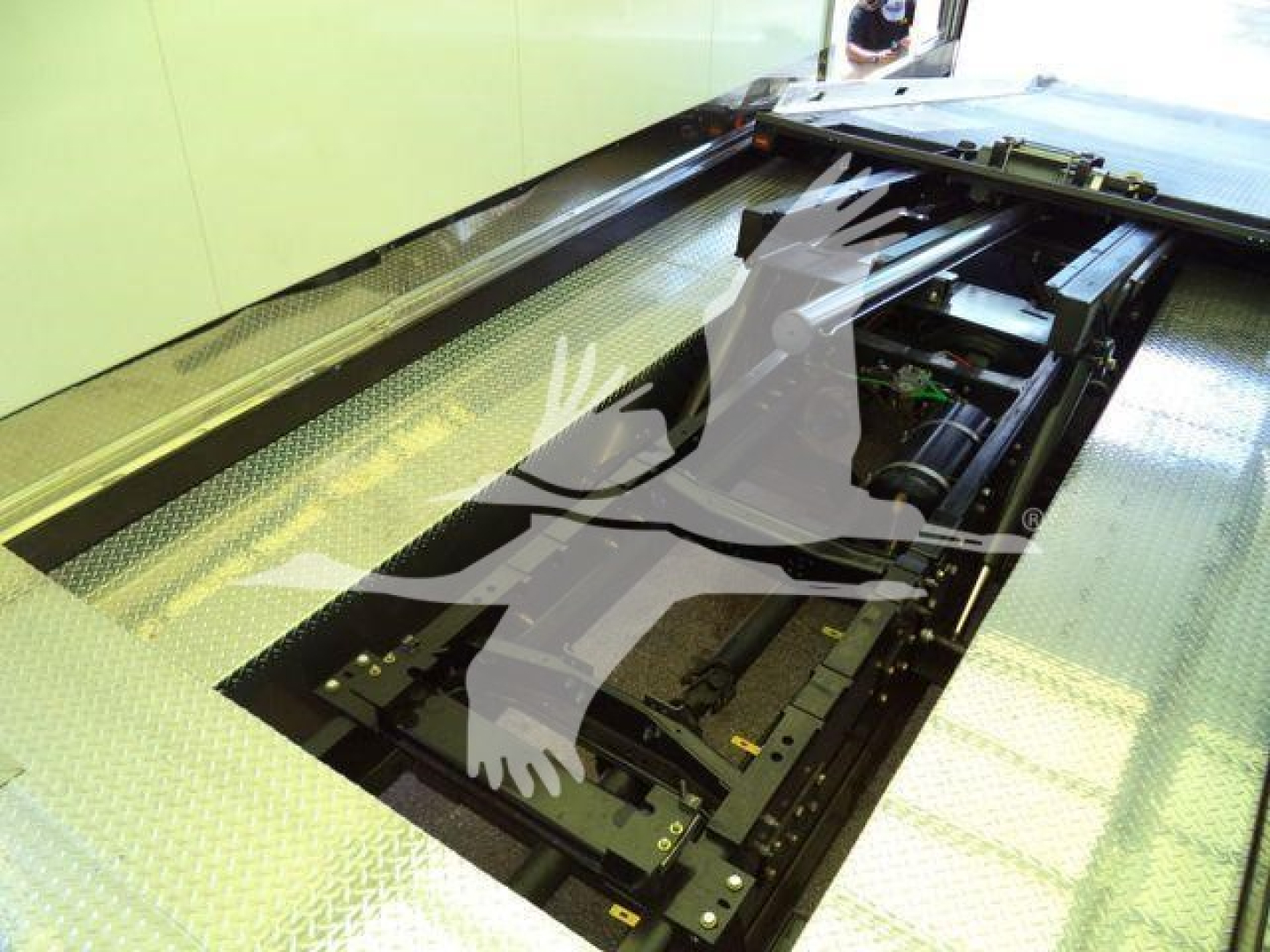 Mack MD6 truck rollback bed interior showing hydraulic components and winch area under open platform.