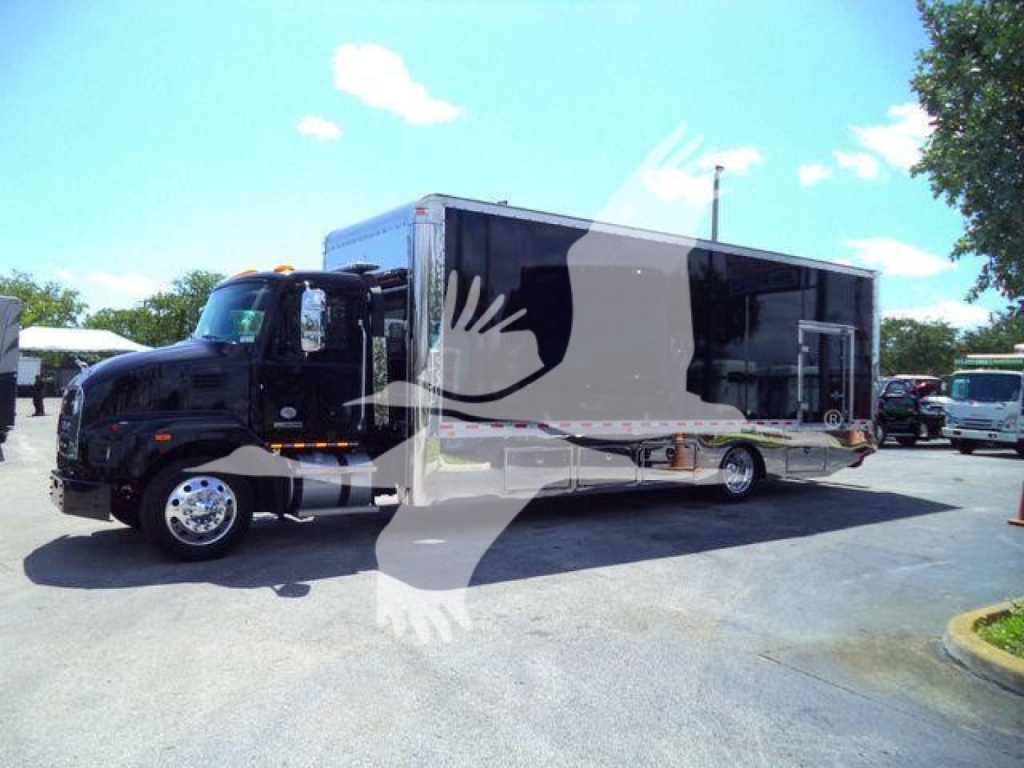 2026 Mack MD6 rollback truck showing a black cab and a large enclosed box body with a white graphic overlay.