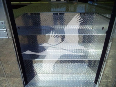 Truck equipment compartment with diamond plate storage boxes in an MD6 rollback truck side, showing metallic finish and utility compartments.