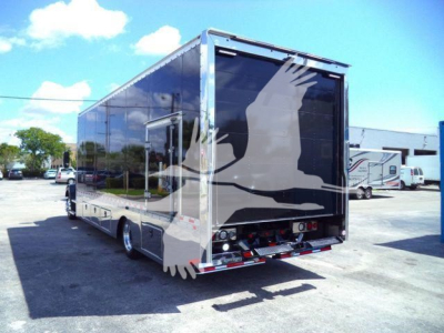 Back view of a 2026 Mack MD6 rollback truck with a large black graphic on the rear doors. Includes taillights, chrome bumper, and rear undercarriage.