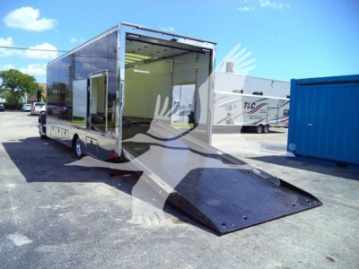 Truck trailer with ramp gate lowered showing interior space and side entry; aluminum enclosure, rear loading ramp, open rear door, Mack MD6 stock photo.