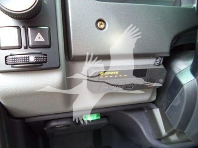 Mack MD6 dashboard area showing a black EzPite? device with yellow markings installed under the steering column. Green lever visible below.