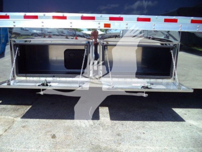 Mack MD6 rollback body showing open tool drawer compartments and chrome edges.