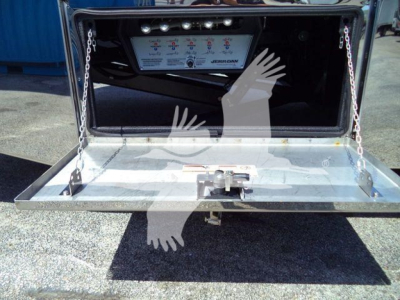 Mack MD6 rollback truck rear with open toolbox showing controls panel and hitch; metal tailgate with chains and hitch receiver.