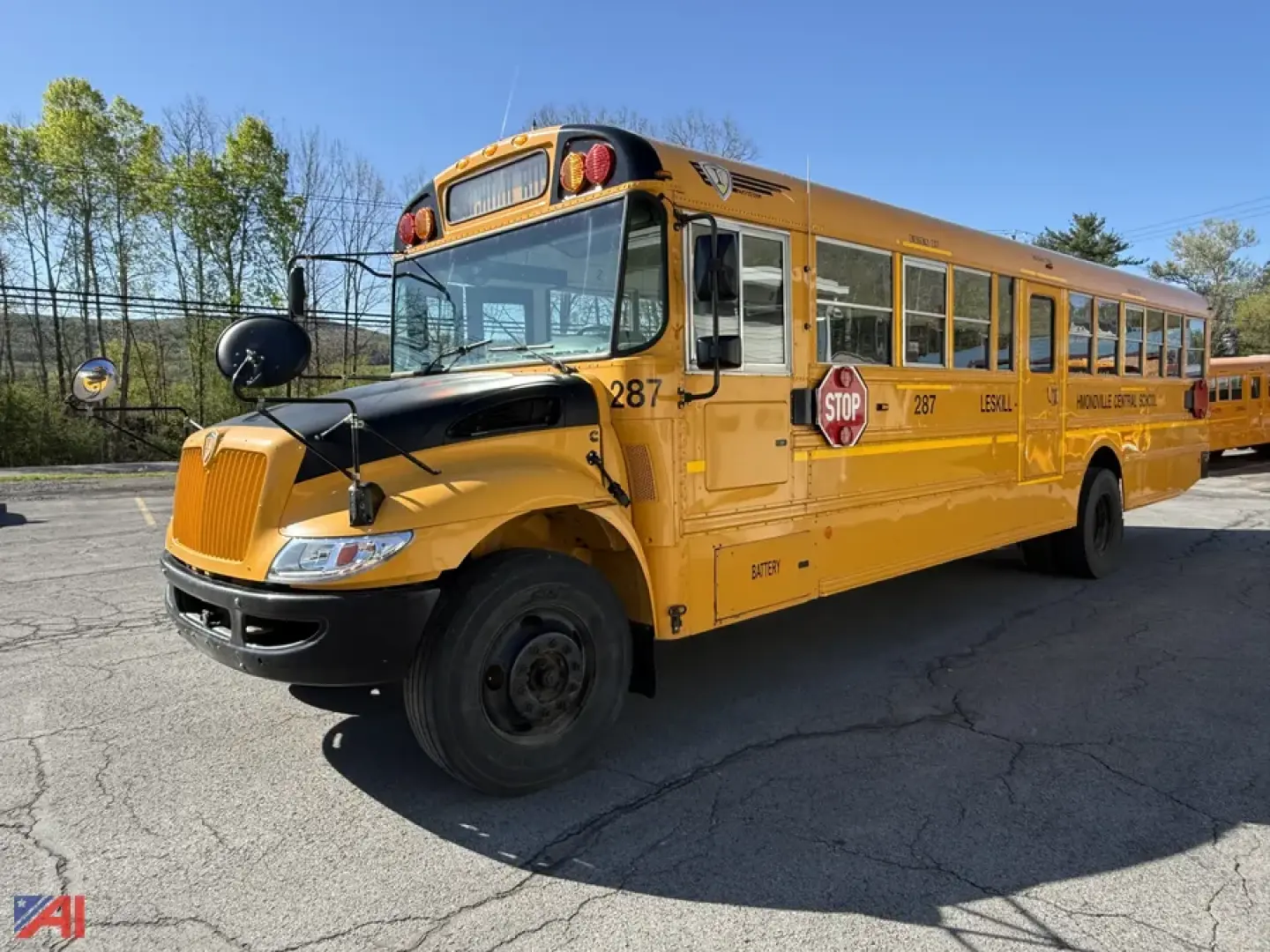 School bus 2018 IC Corporation CE Series, yellow, front-left view, with stop sign extended and door open on the passenger side; bus number 287 visible near front; black bumper and mirrors.
