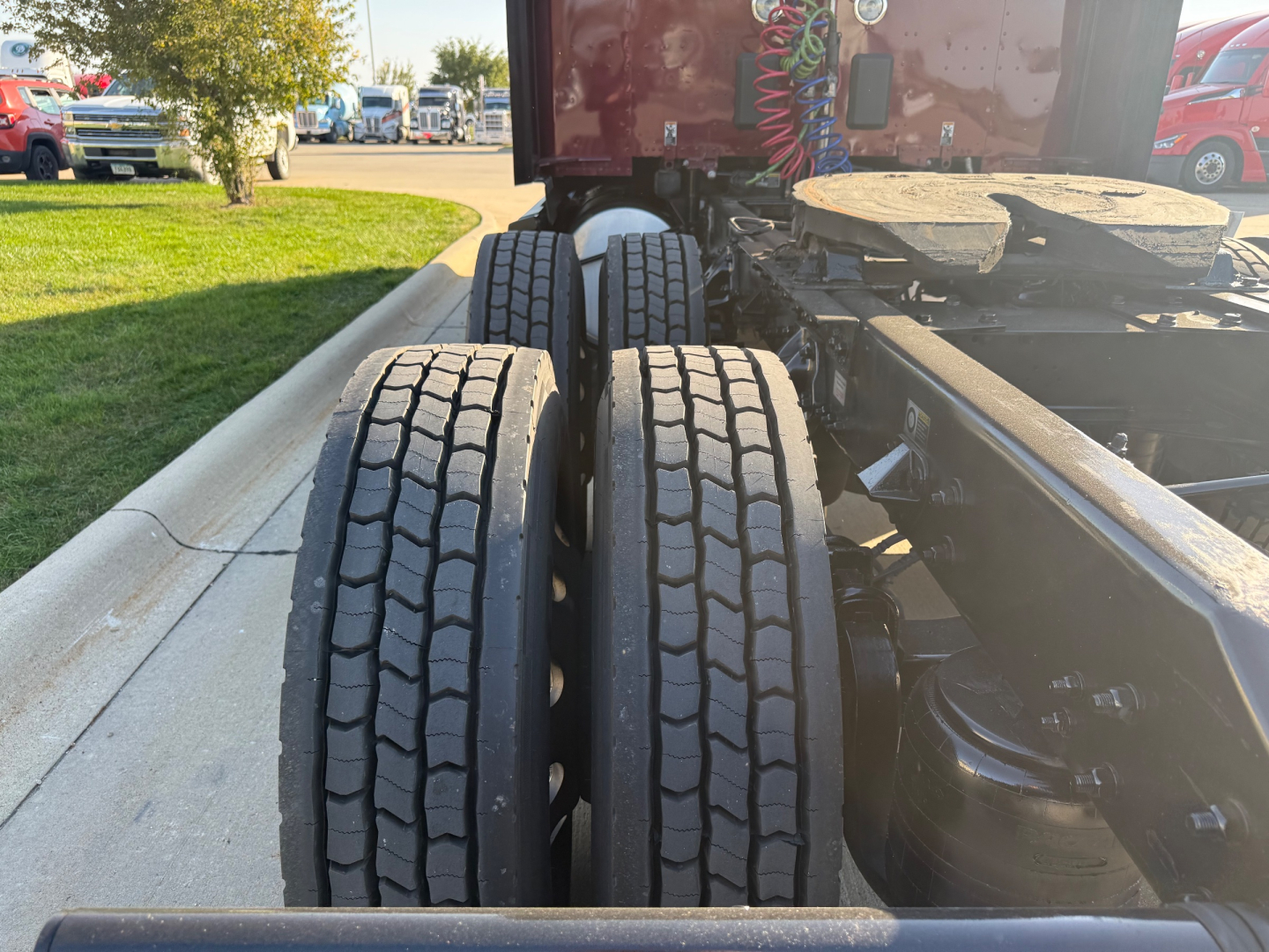 Kenworth T680 chassis with dual rear axles and tires visible, view from side showing fifth wheel and part of sleeper cab rear.