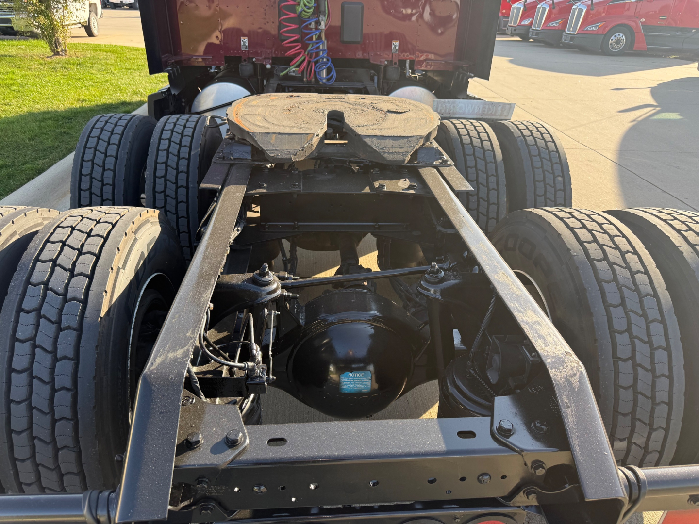Kenworth T680 rear chassis frame and drivetrain showing dual rear axles and suspension components beneath cab, with fifth wheel mount and drive shafts visible.