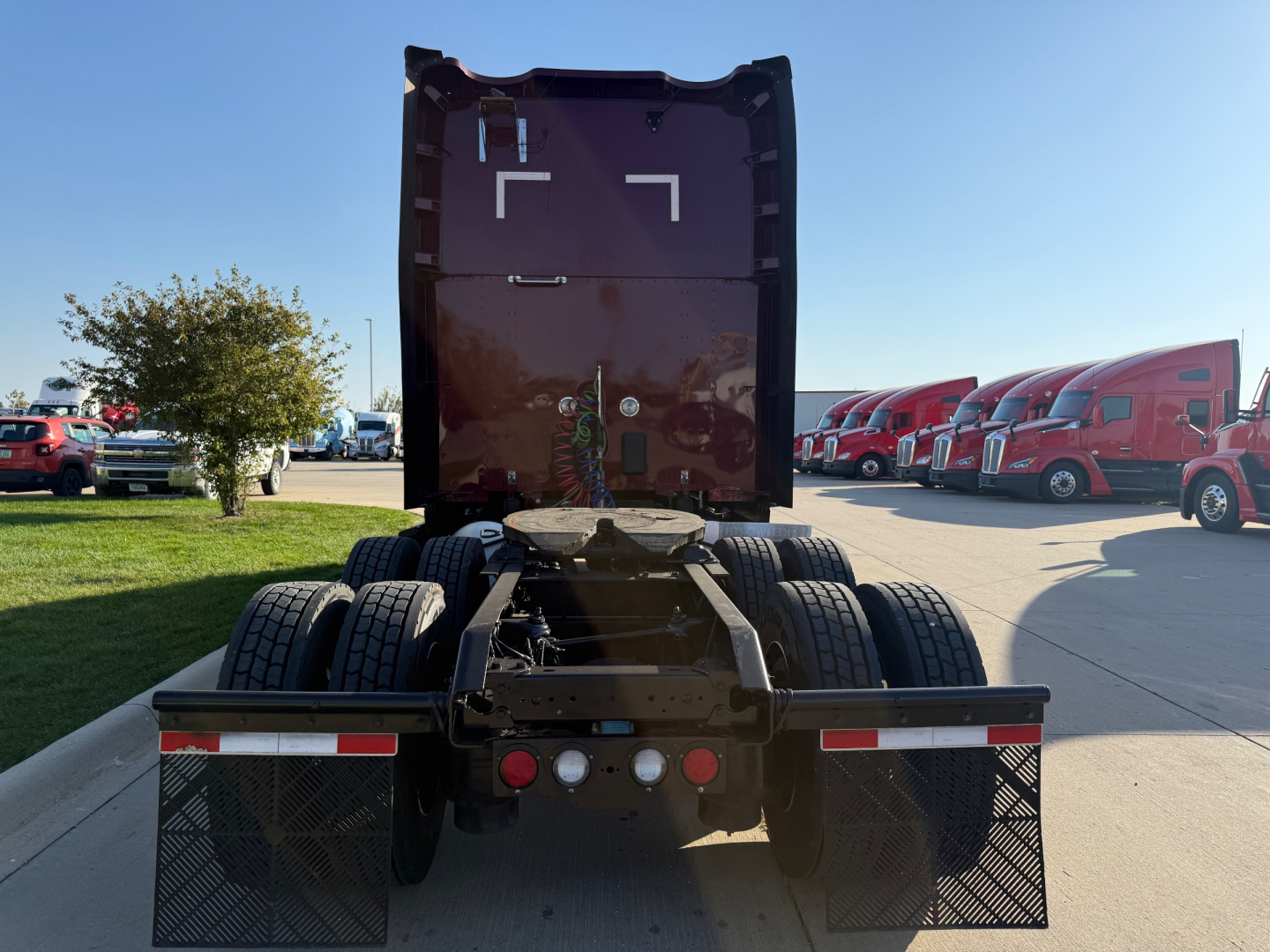 Kenworth T680 tractor rear view showing fifth wheel, dual rear axles, and rear mud flaps.