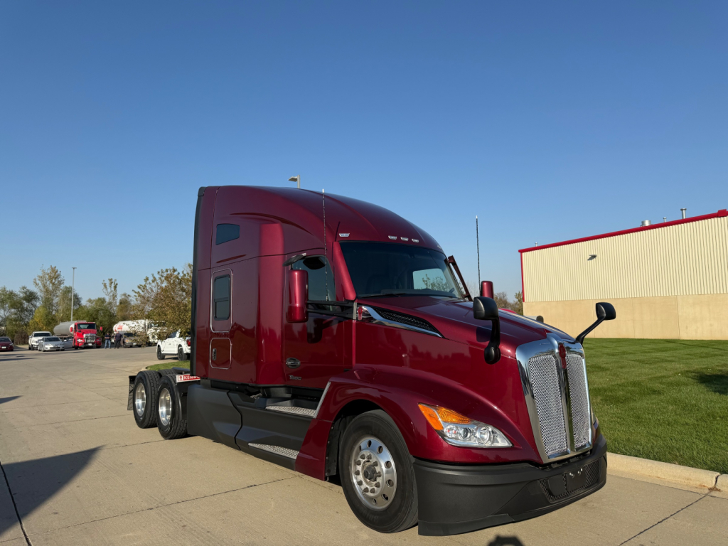 Kenworth T680 cab tractor in maroon color, side view showing front grille, headlights, and dual rear axles; no visible text on components.