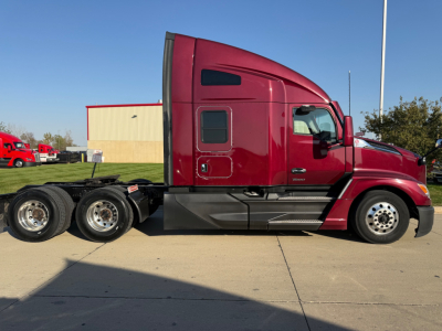 Kenworth T680 conventional sleeper truck side view showing cab and rear wheels with burgundy paint.