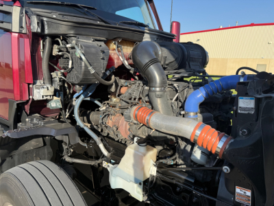 Kenworth T680 engine bay showing intake hose, coolant reservoir, and various hoses and components.