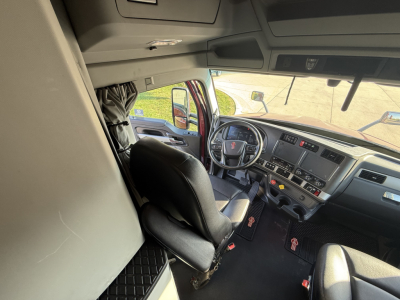 Kenworth T680 truck interior view of driver seat and dashboard; visible steering wheel, instrument panel, and pedals.