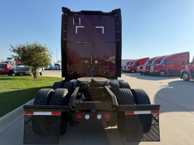 Kenworth T680 tractor rear view showing fifth wheel, dual rear axles, and rear mud flaps.