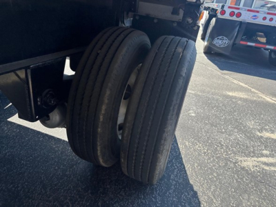 Dual rear tires on a utility spread air combo flatbed trailer showing tread and wheel rims.