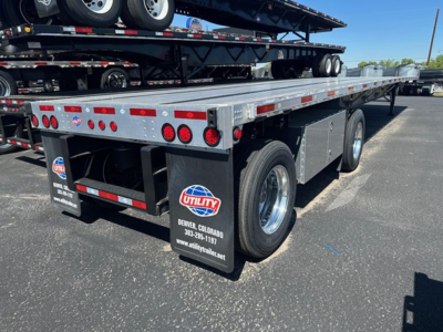 Trailer rear/side view showing Utility Spread Air Combo Flatbed with dual rear wheels, multiple taillights, and Utility branding on mud flaps.