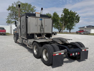 Kenworth W-900L AeroCab tractor rear view showing dual rear axles, fifth wheel, and fuel tanks.