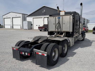 Kenworth W-900L AeroCab tractor rear view showing dual rear axles, fifth-wheel area, and exhaust stacks.