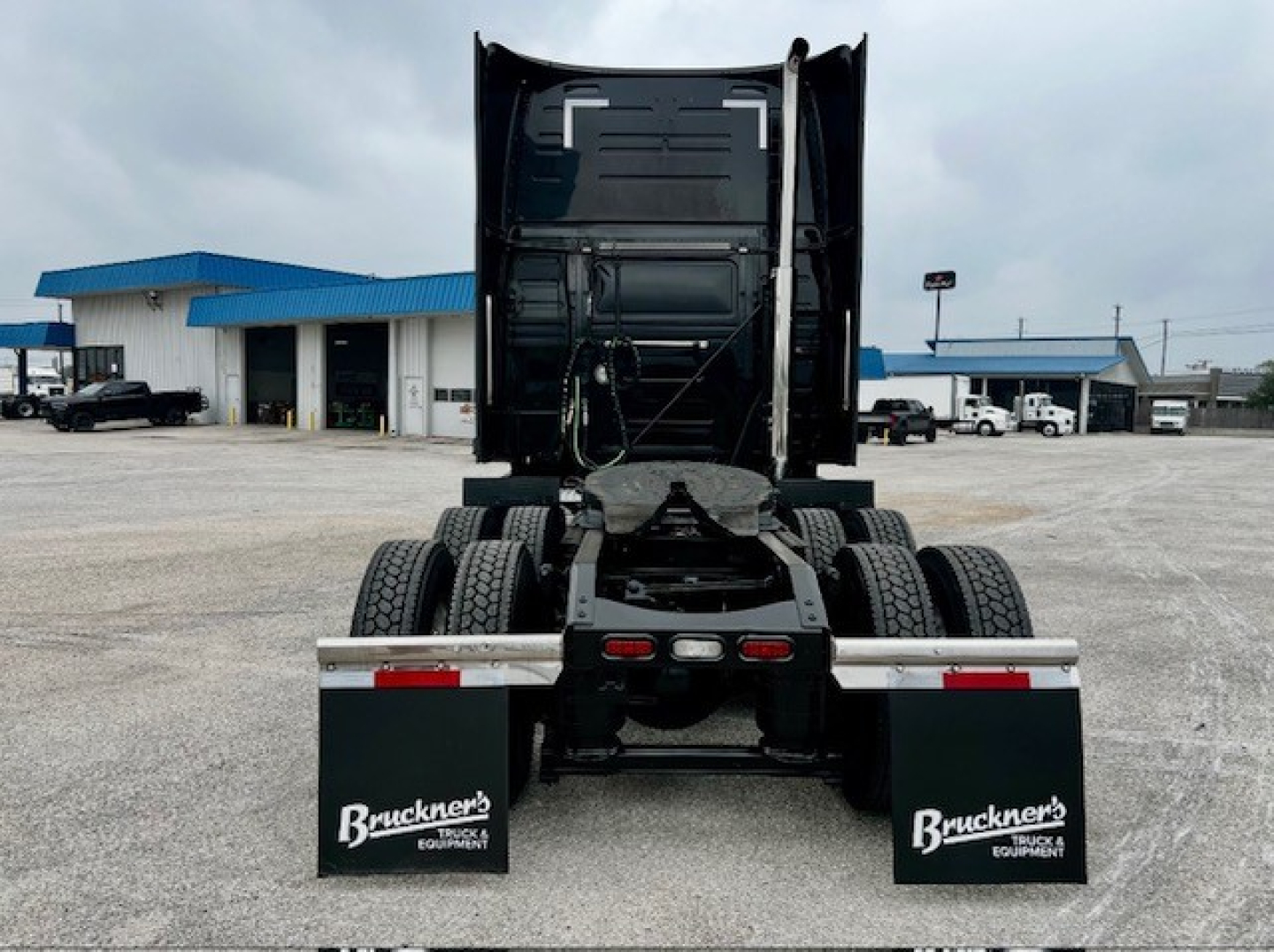 Rear view of a Volvo VNL860 truck tractor with fifth wheel and dual rear axles, mud flaps reading Bruckner's Equipment.