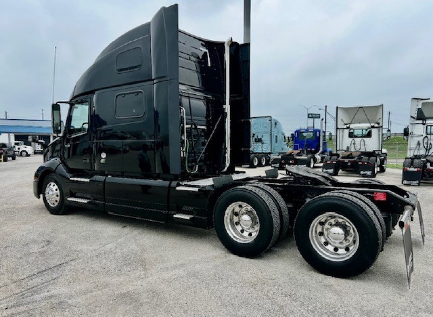 Volvo VNL860 sleeper cab truck side view showing dual rear axles and black exterior.